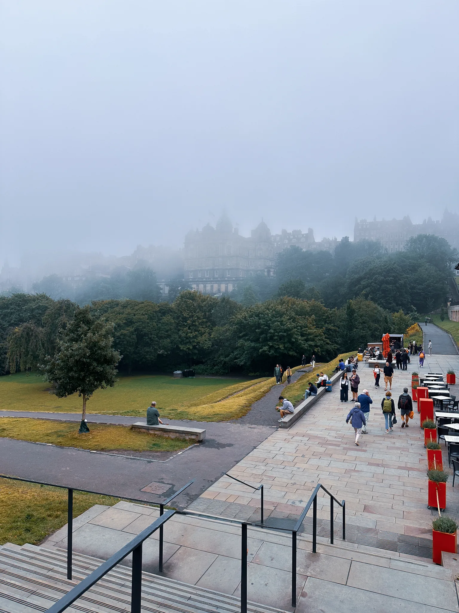 The haar sitting on the Old Town, the Bank of Scotland half-dissolved above the gardens while people cross the gallery terrace below