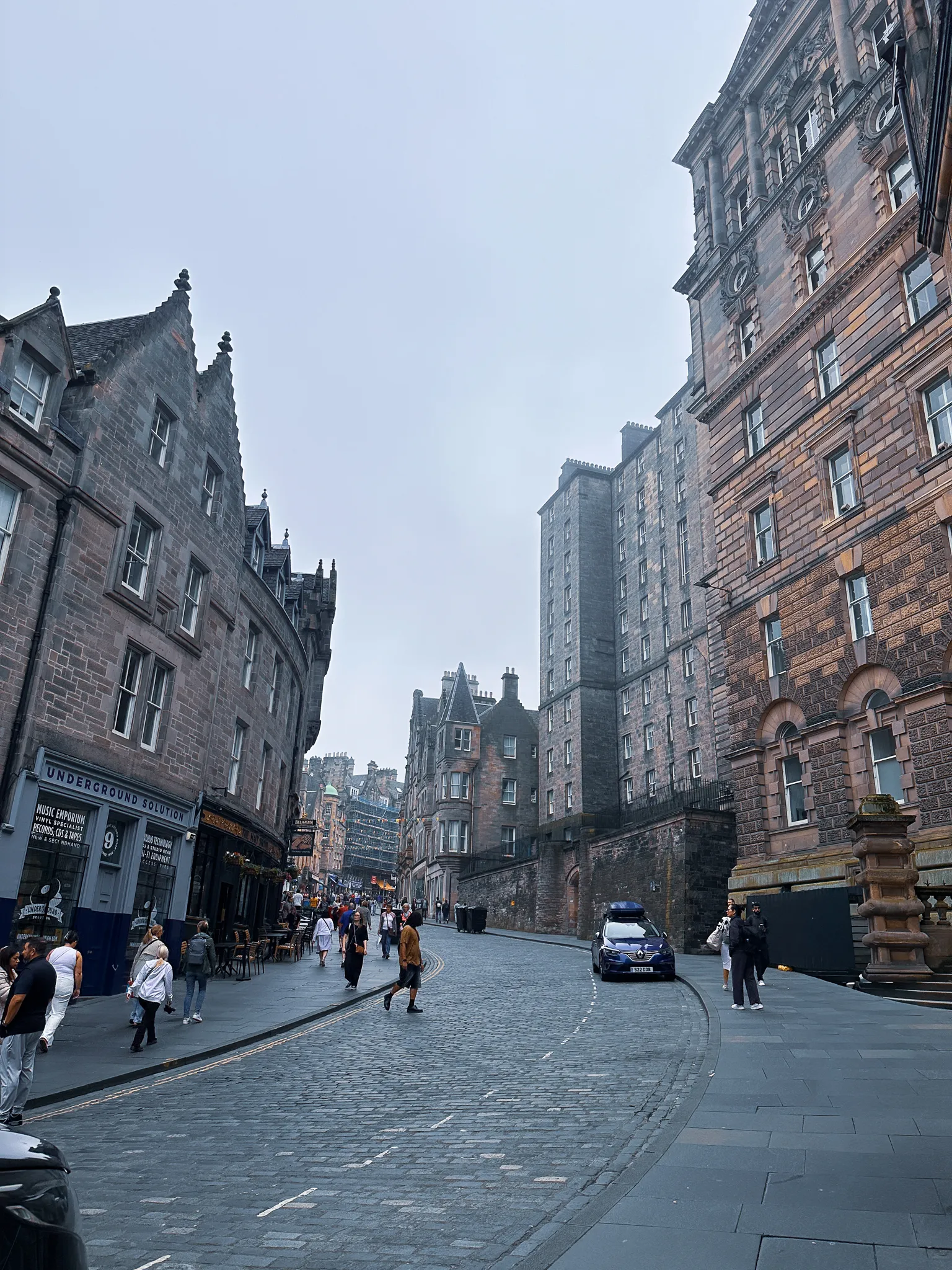Cockburn Street curving up between baronial tenements, the Underground Solution record shop holding the corner