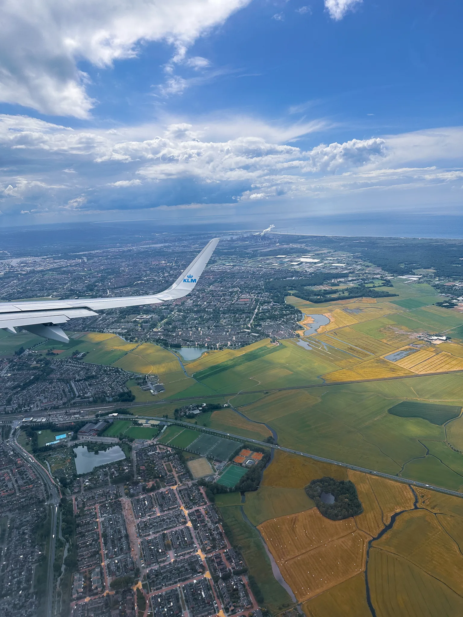 Leaving over the Netherlands - a KLM winglet above the polders on the Schiphol connection, the North Sea out on the horizon