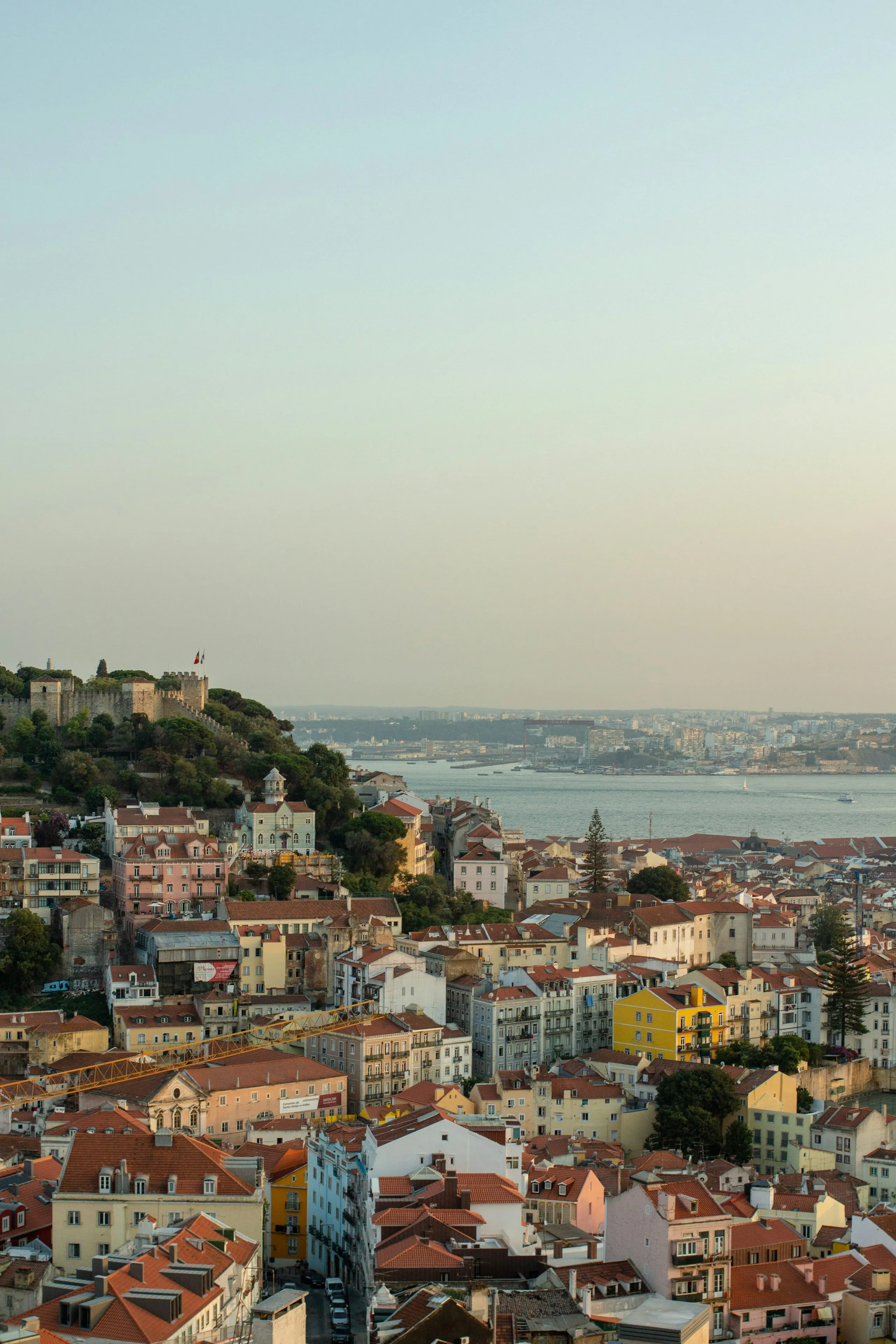 Terracotta rooftops running down to the river, the castle walls on the hill above and the water pale in the distance