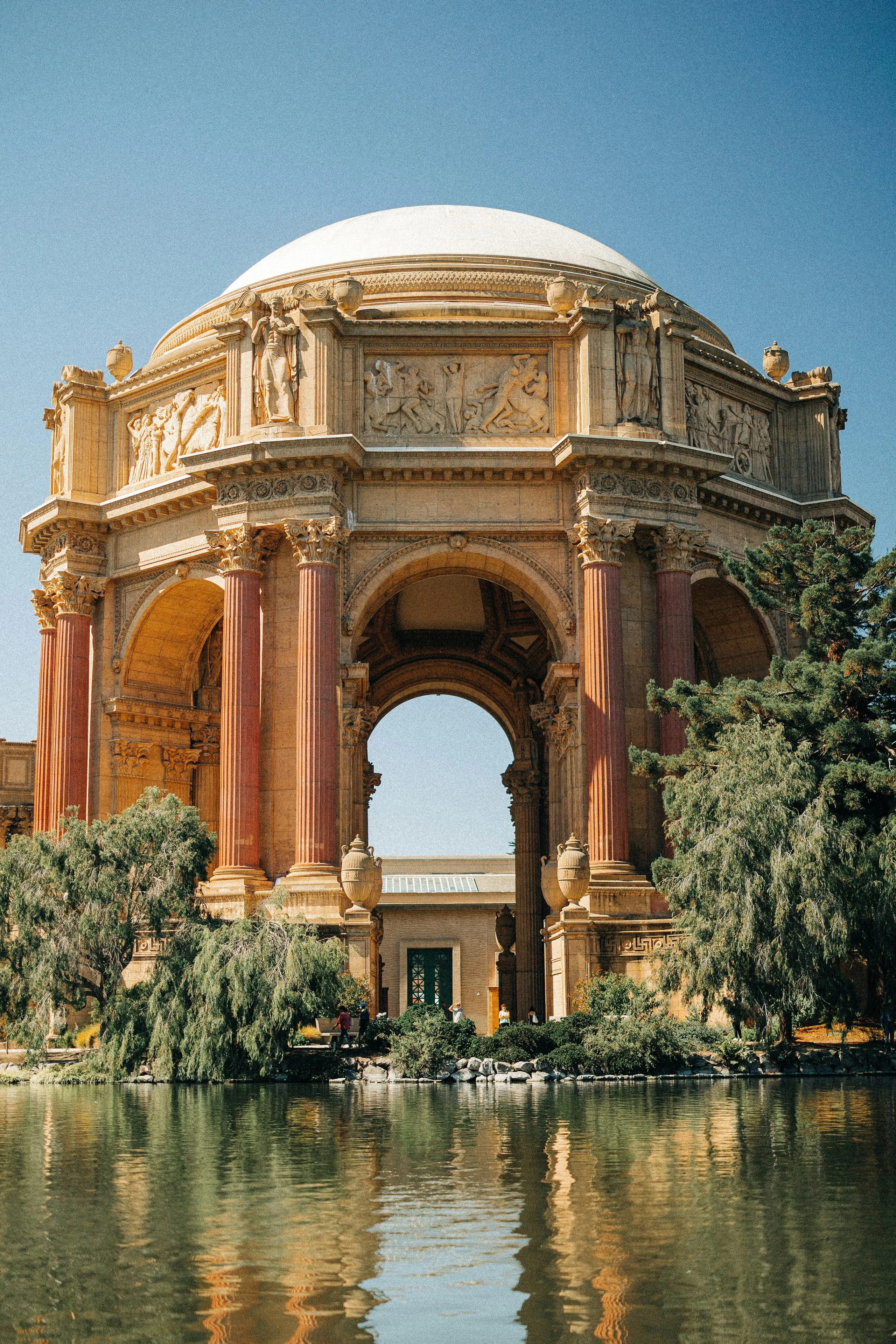 The domed rotunda and colonnade of the Palace of Fine Arts reflected in the still lagoon in front of it
