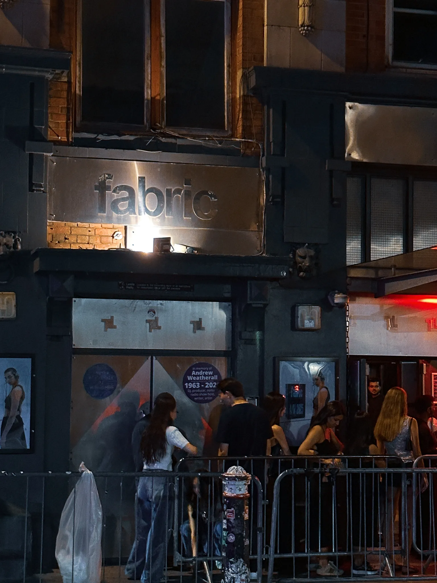The steel fabric sign over the club's doors, a memorial notice for Andrew Weatherall taped inside the glass and people gathered at the barriers outside