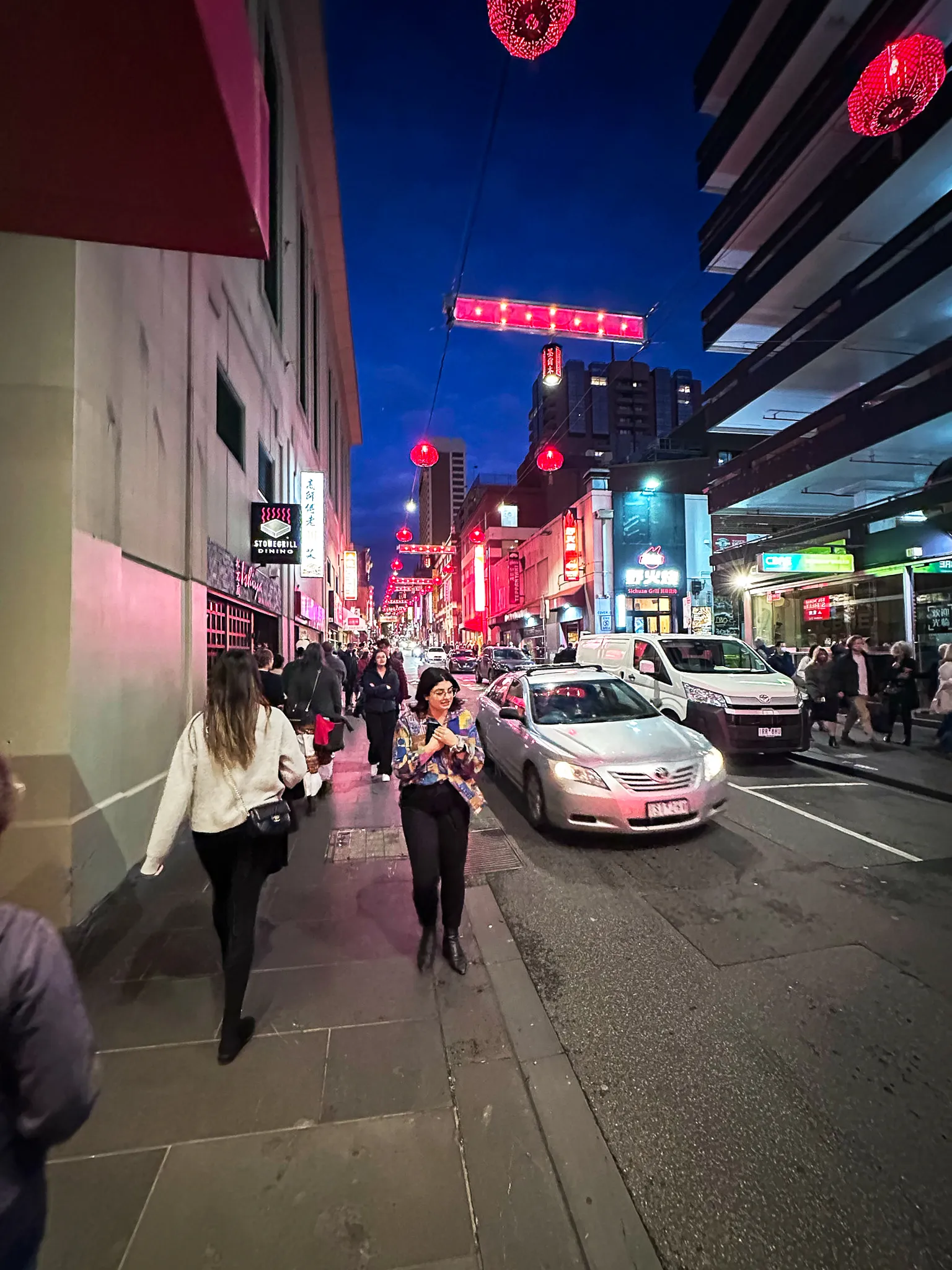 Little Bourke Street at blue hour, red lanterns strung overhead and neon signs down the block