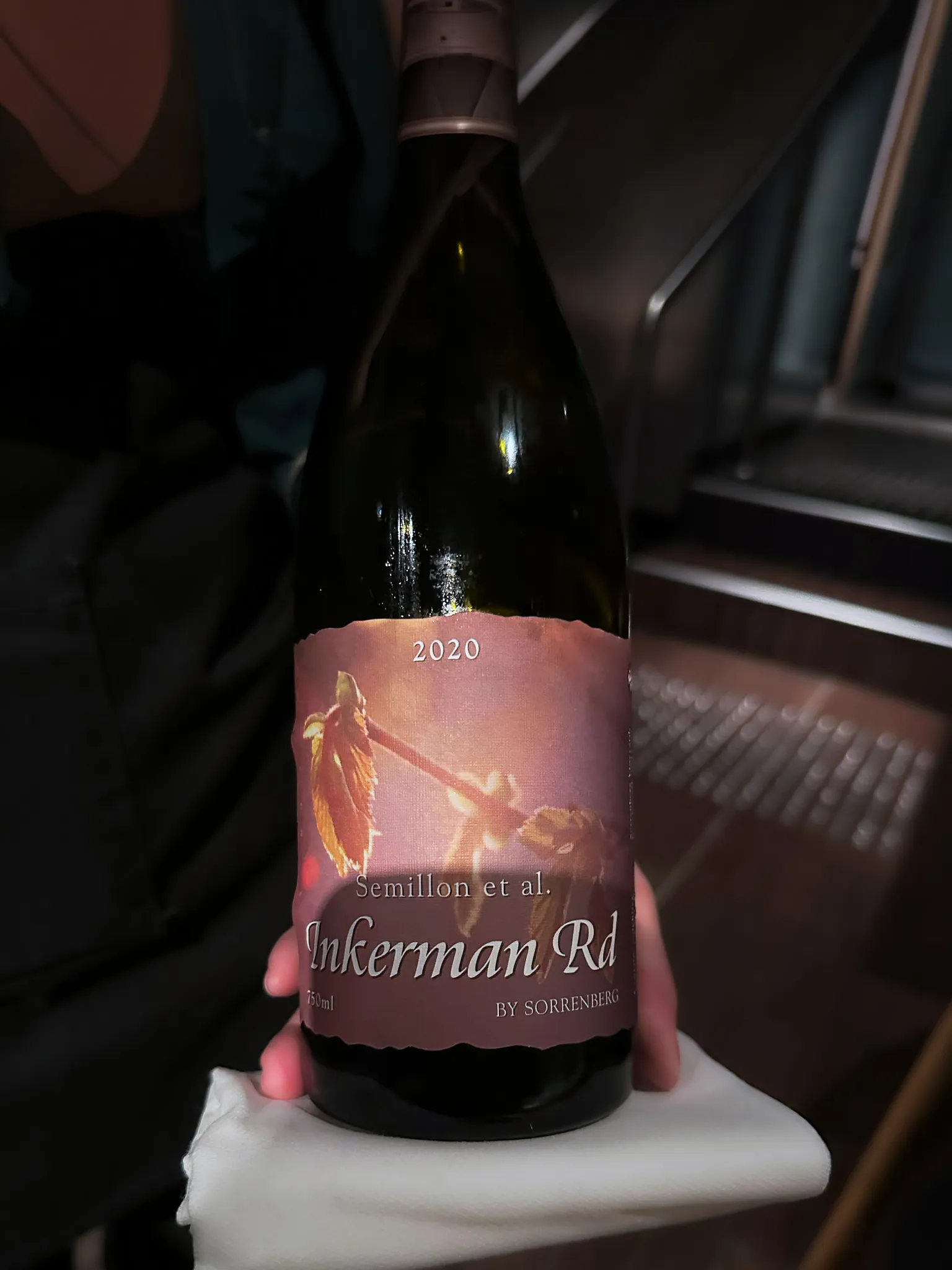 A waiter presenting a 2020 Sorrenberg 'Inkerman Rd' Semillon, the bottle resting on a folded white napkin