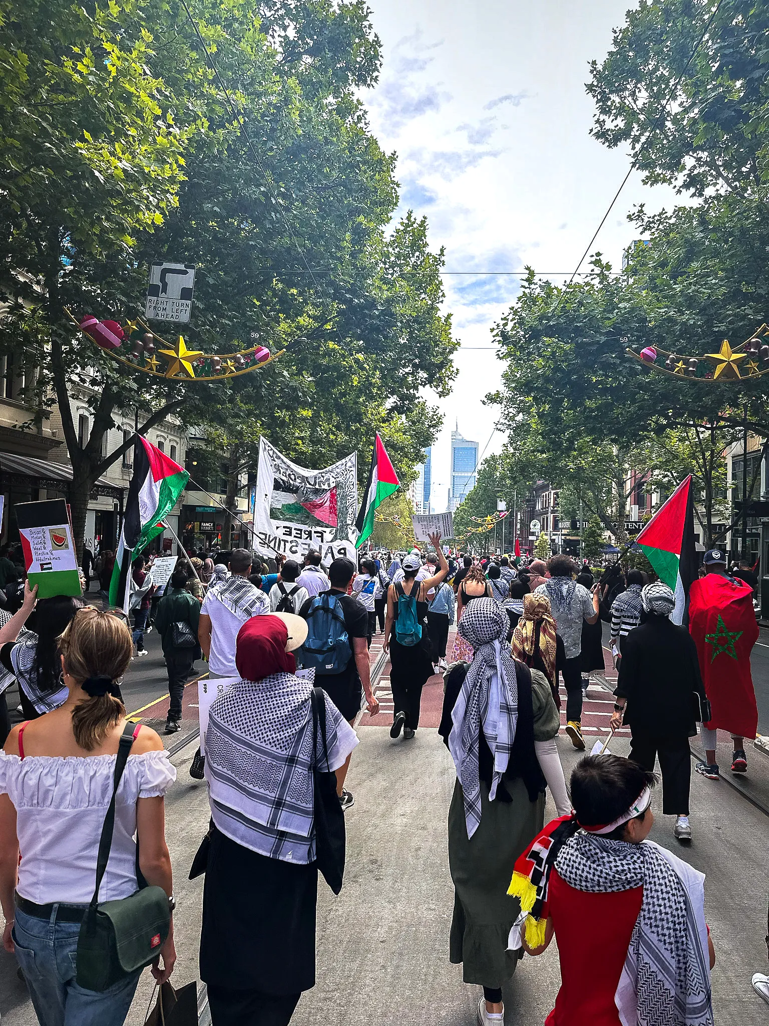 A march down Bourke Street Mall, Palestinian flags and banners carried above the crowd